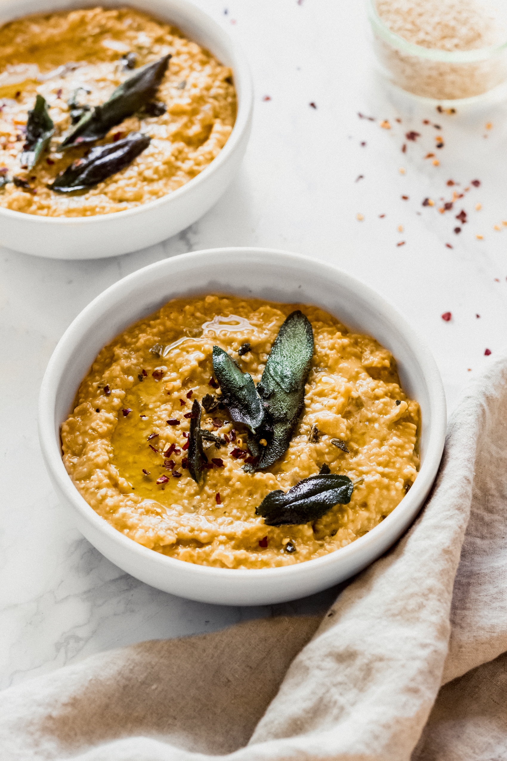 Two bowls of pumpkin sage oat risotto