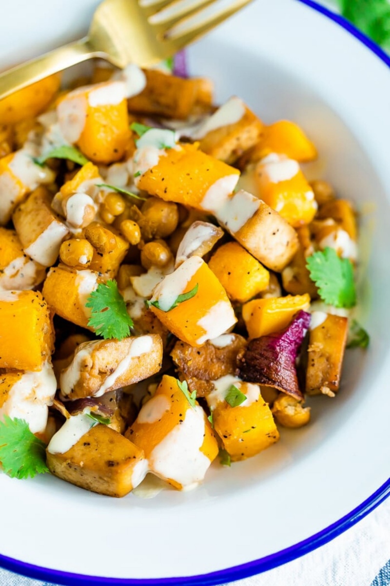 white bowl with butternut squash and a drizzle sauce 