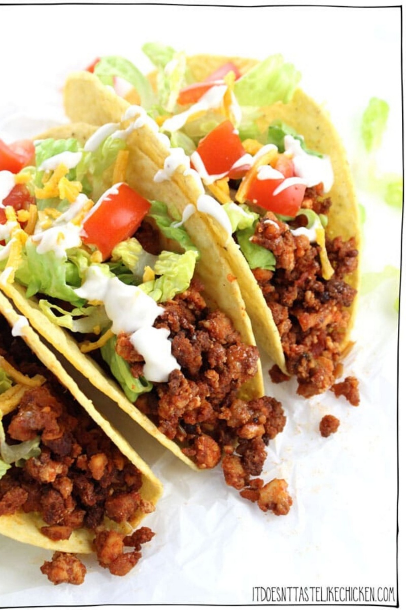 three hard shell tacos with lettuce and tomatoes