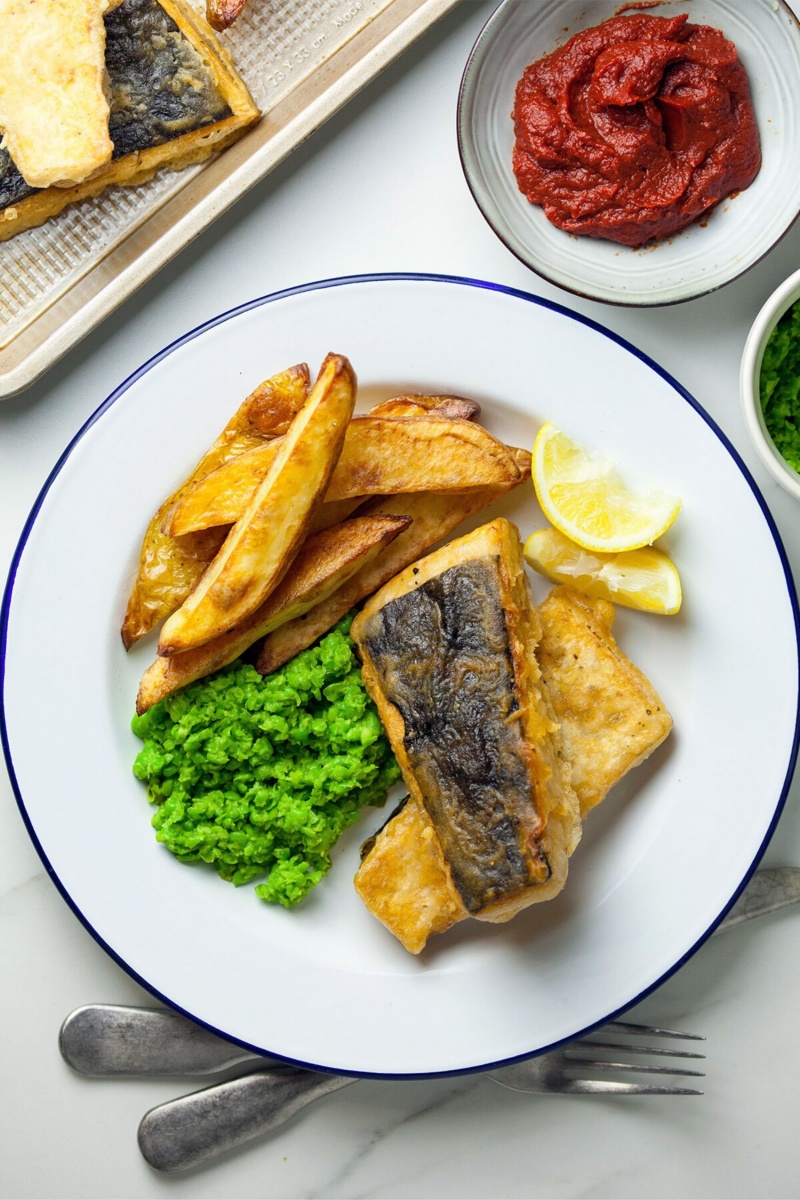 tofu with potato fries on a white plate with a blue border