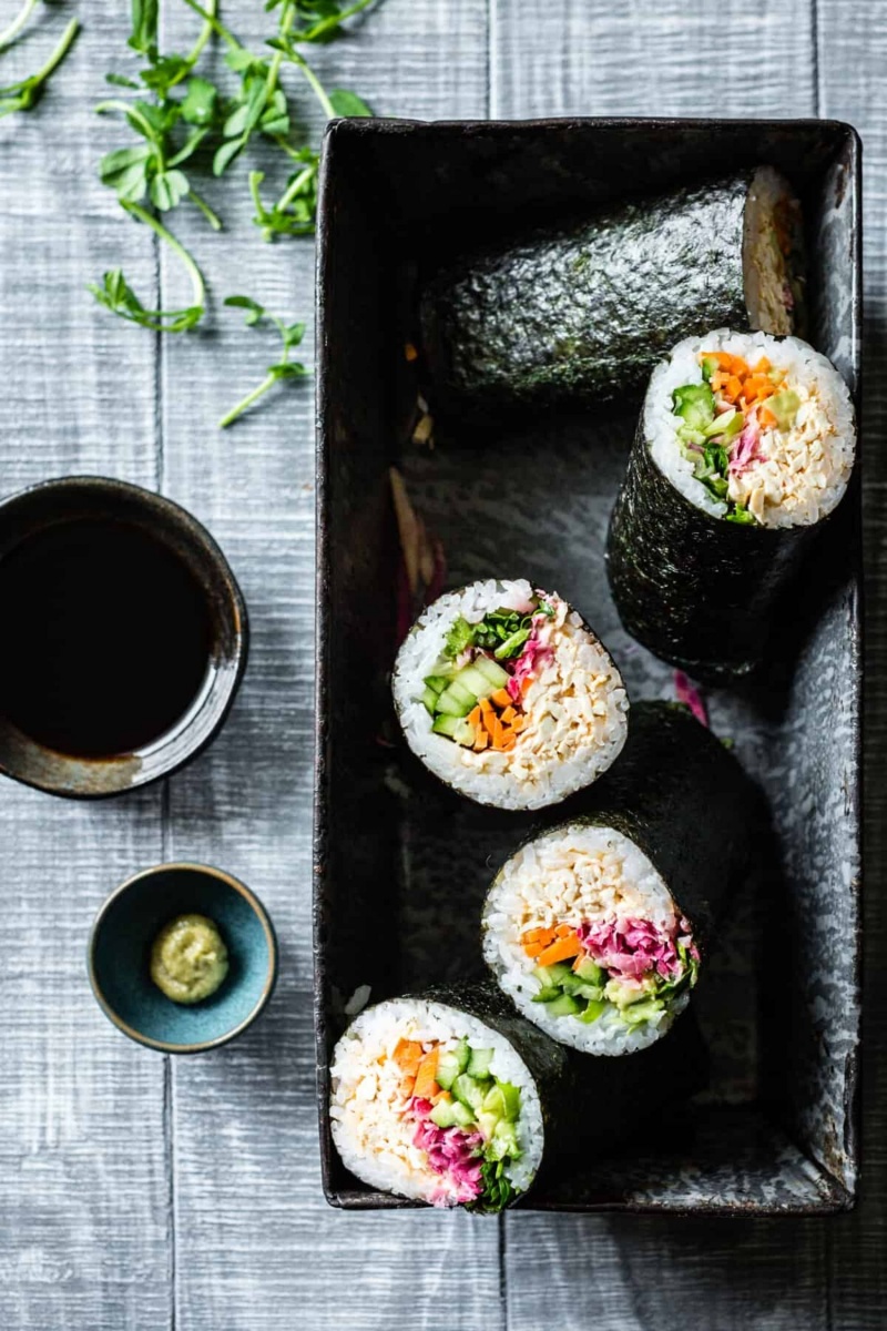 black rectangle plate with four sushi burritos