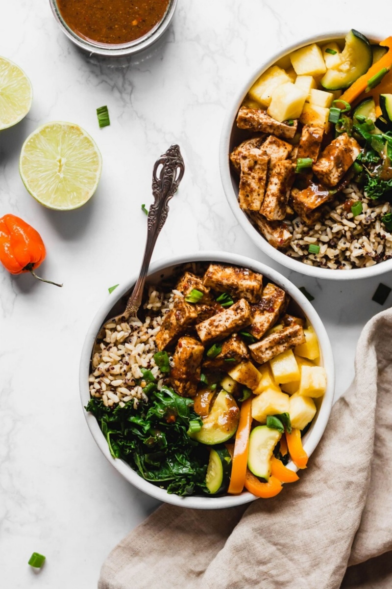 white bowl on a marble table with tofu and vegetables