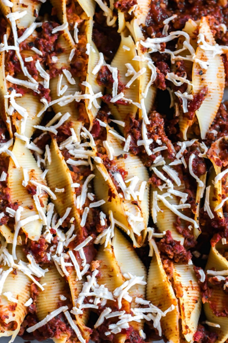 close up of stuffed shells with red sauce and cheese