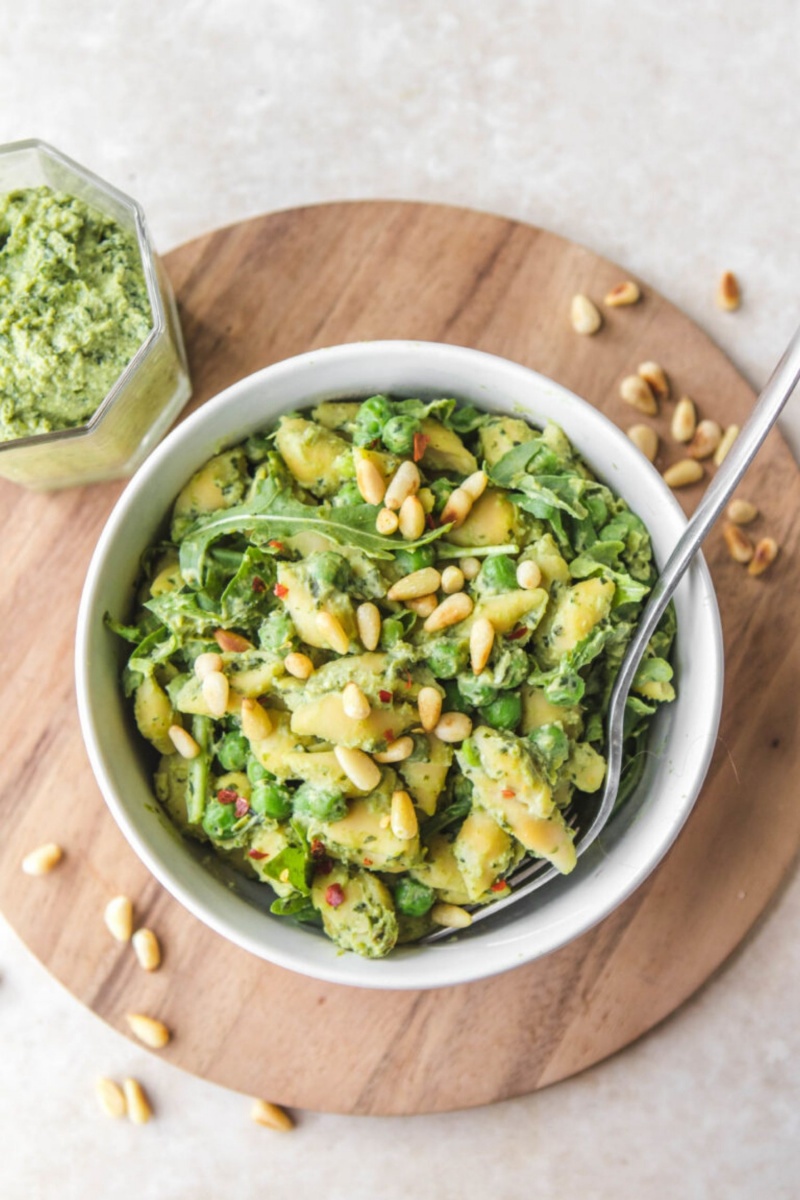 pea pesto pasta in a white bowl on a wooden trivet