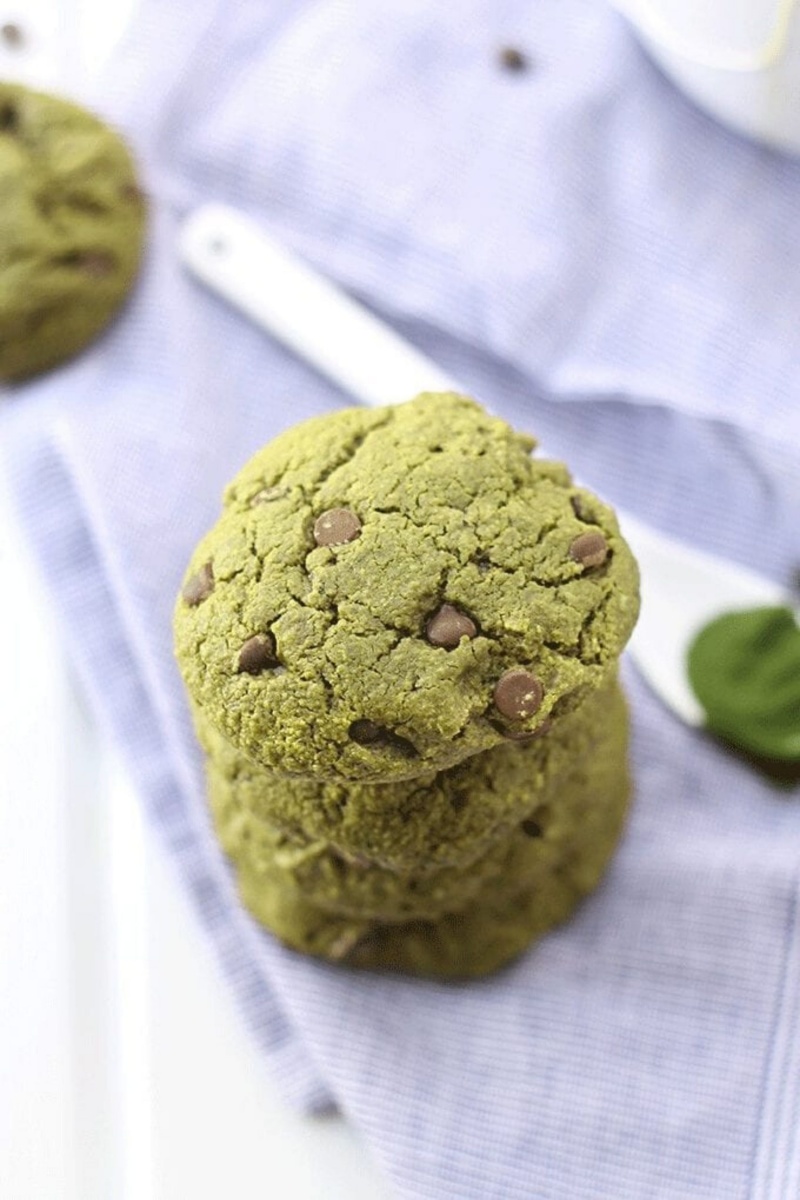 stack of green chocolate chip cookies on a white cloth