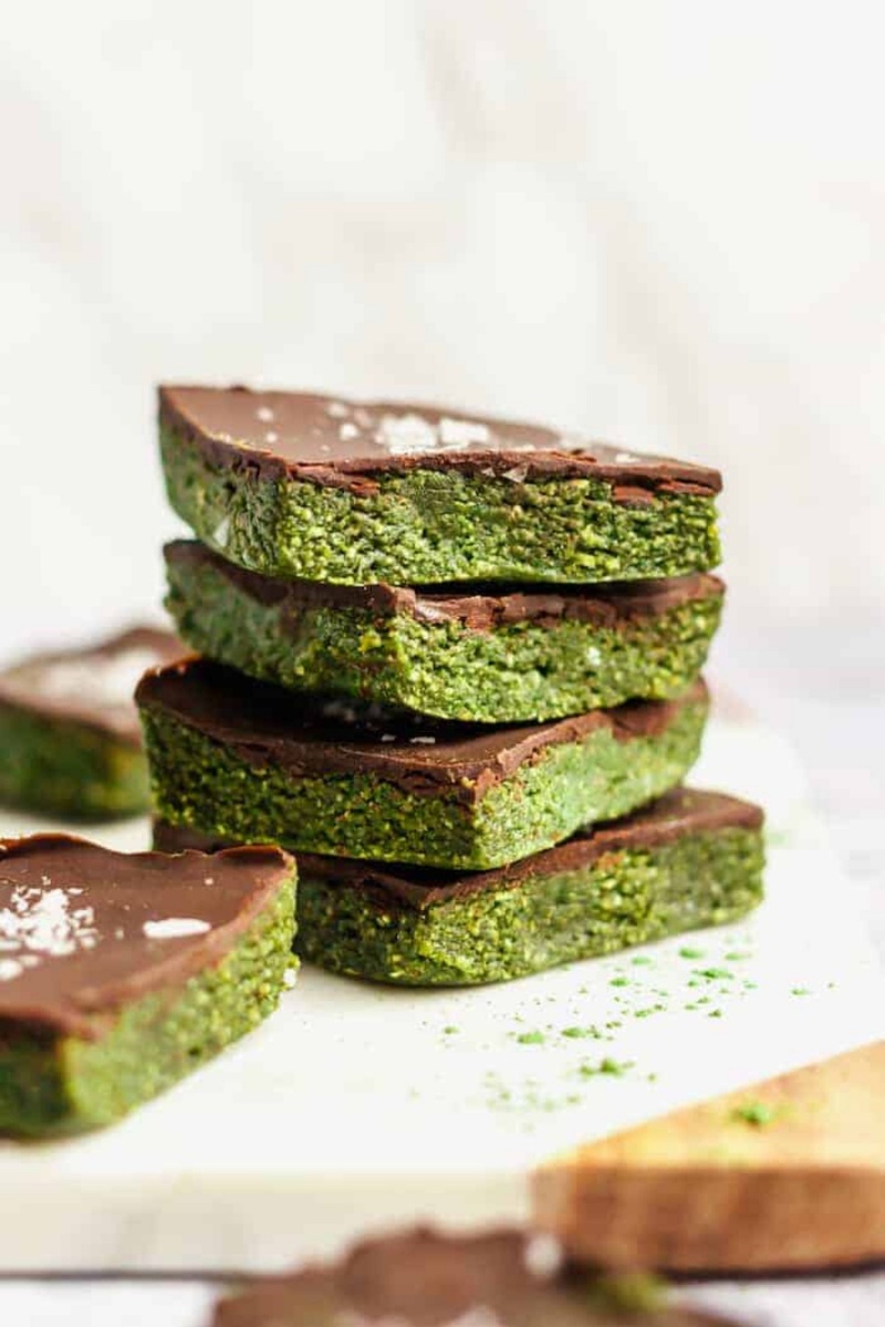 stack of four green protein bars with chocolate topping and sea salt