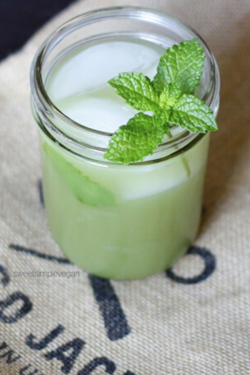 glass with ice and green drink topped with mint sprig