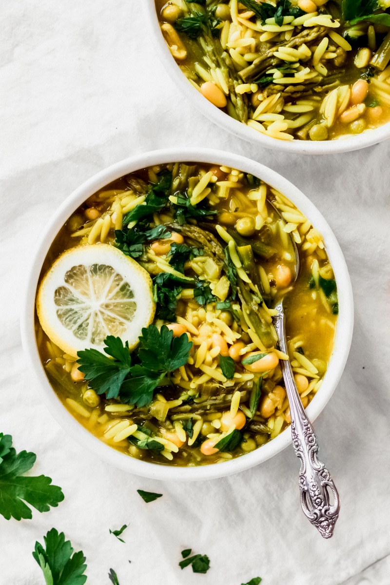 white bowl of yellow lemon orzo soup