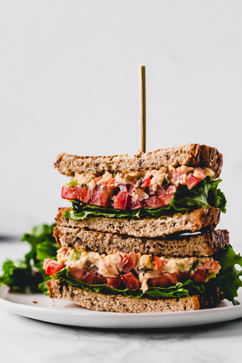 stack of two skewered vegan sandwiches with vegetables and lettuce 