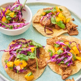 three tempeh tostadas each topped with mango slaw