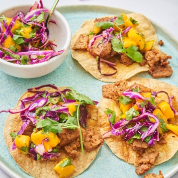 three tempeh tostadas each topped with mango slaw