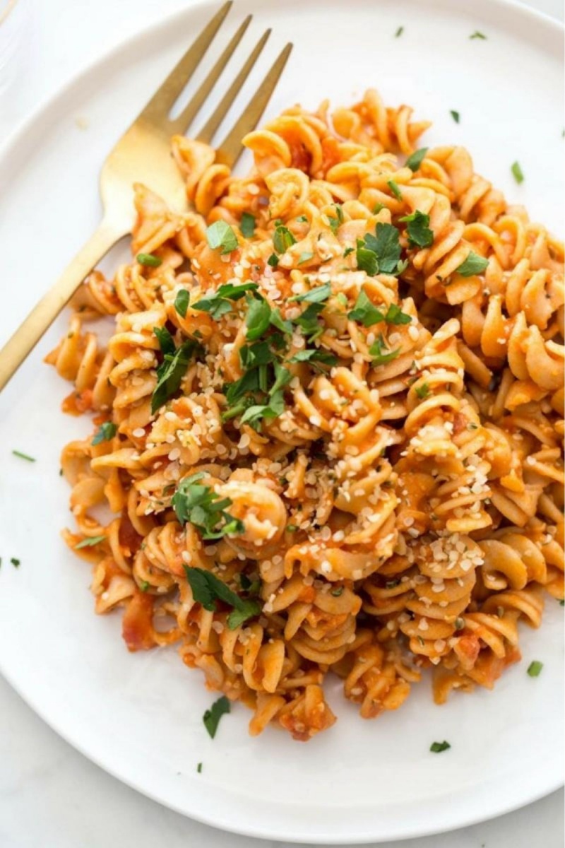 white plate of red rotini pasta