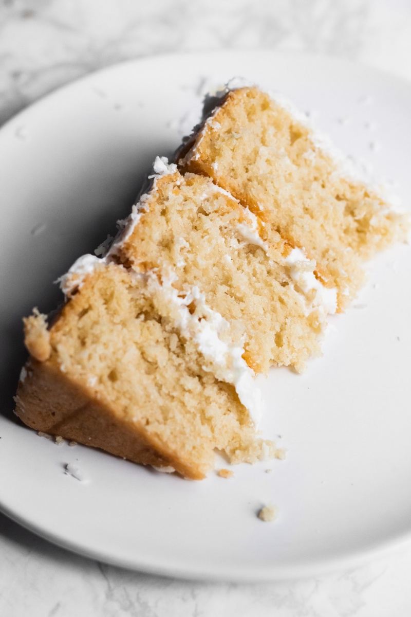 one slice of vegan coconut cake on white plate