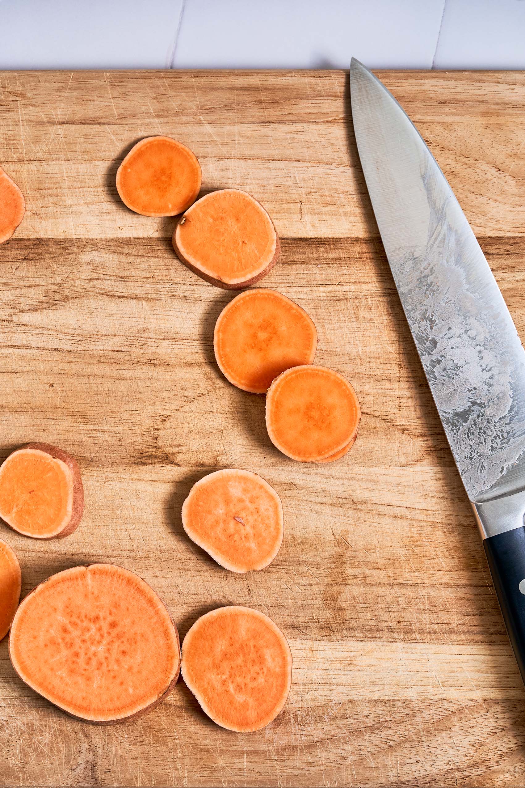 a cutting board of sliced sweet potatoes