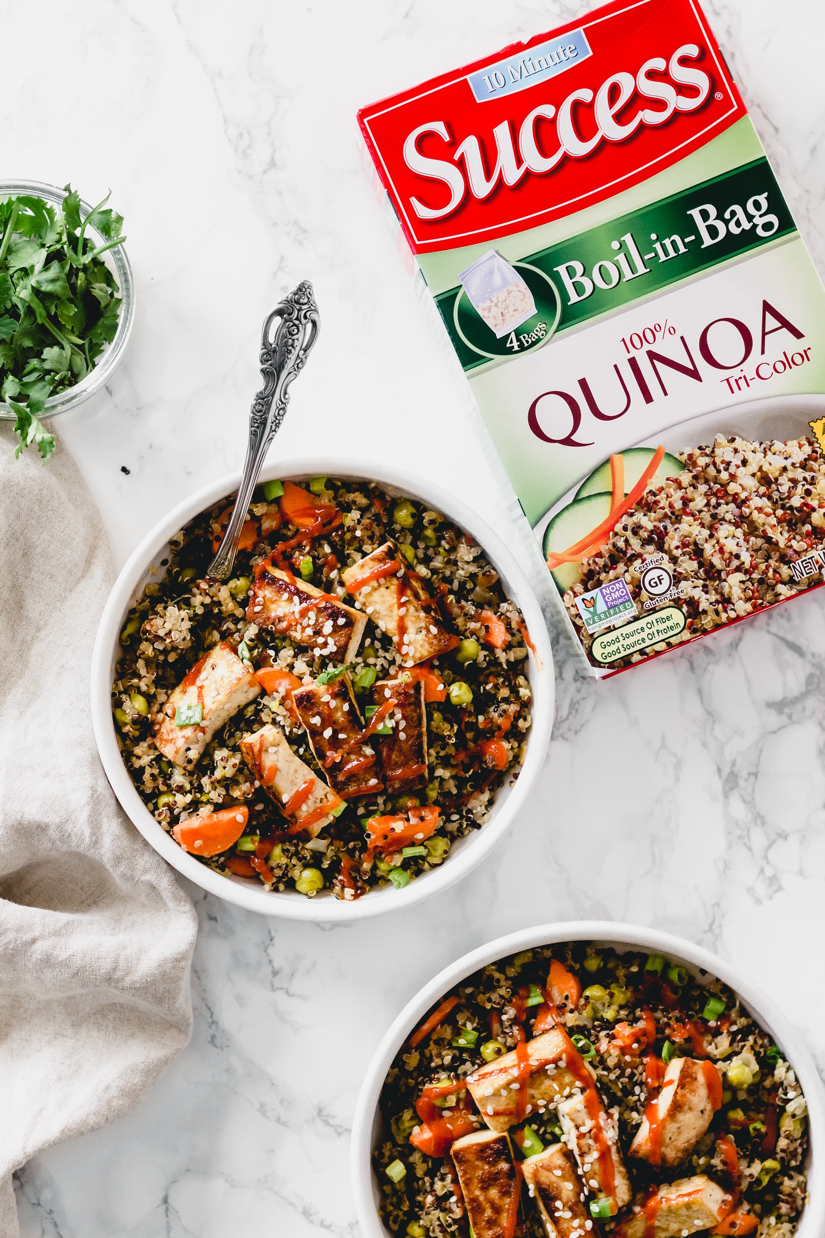 a box of quinoa next to a bowl of fried quinoa and tofu