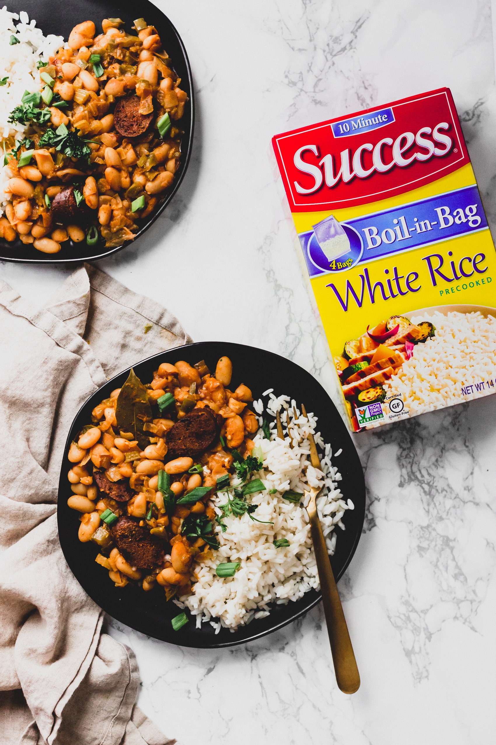 a box of Success white rice next to two plates of cajun white beans