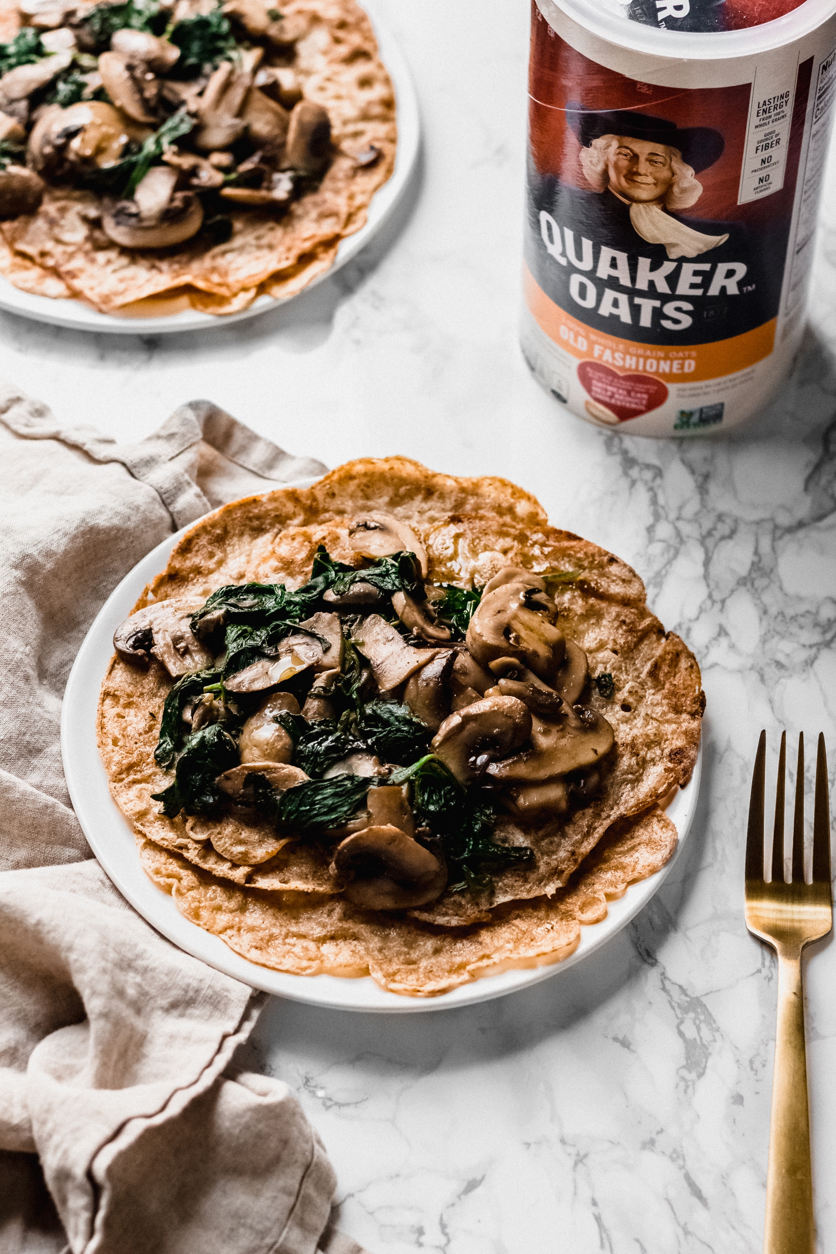 a vegan crepe topped with sauteed mushrooms and spinach