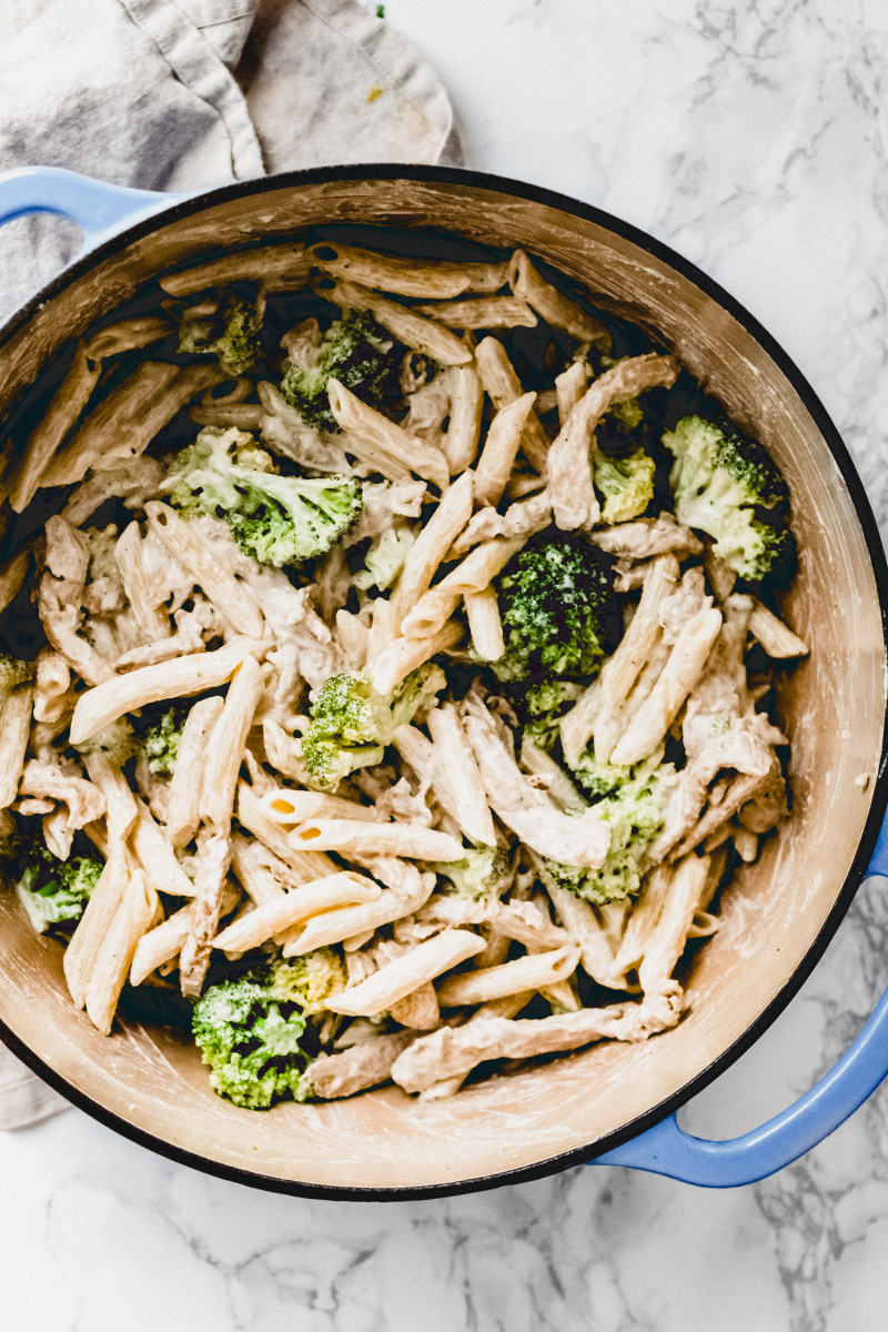 large pot full of pasta with alfredo sauce, broccoli, and soy curls