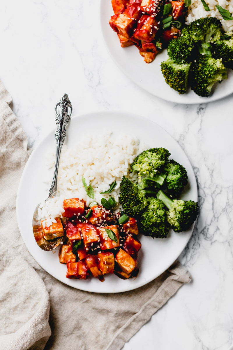 close-up of a plate of sweet and sour tofu with broccoli and rice