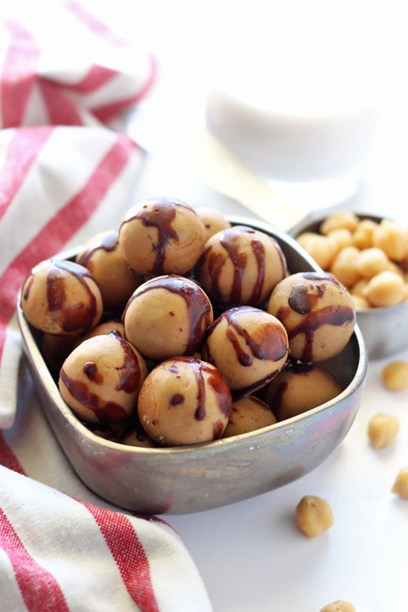 A bowl of chickpea protein balls covered in a drizzle of chocolate