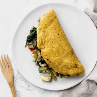 plant based omelette stuffed with vegetables, avocado, and cheese