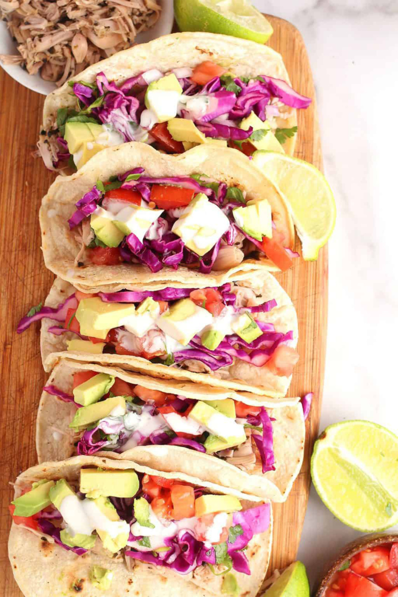 a tray of vegan fish tacos served with limes