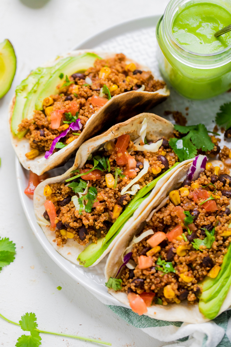 a plate of vegan quinoa tacos served with avocado slices