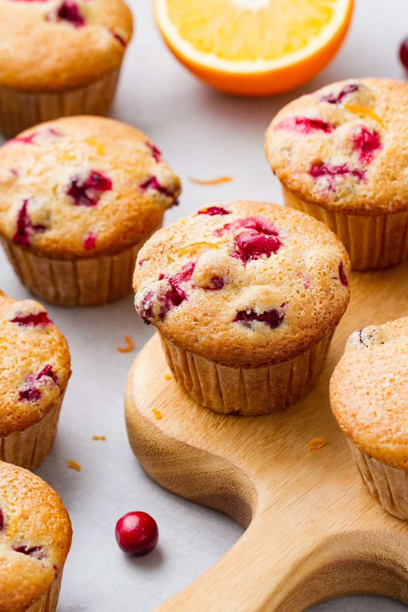 Cranberry orange muffins plated on a wooden serving board
