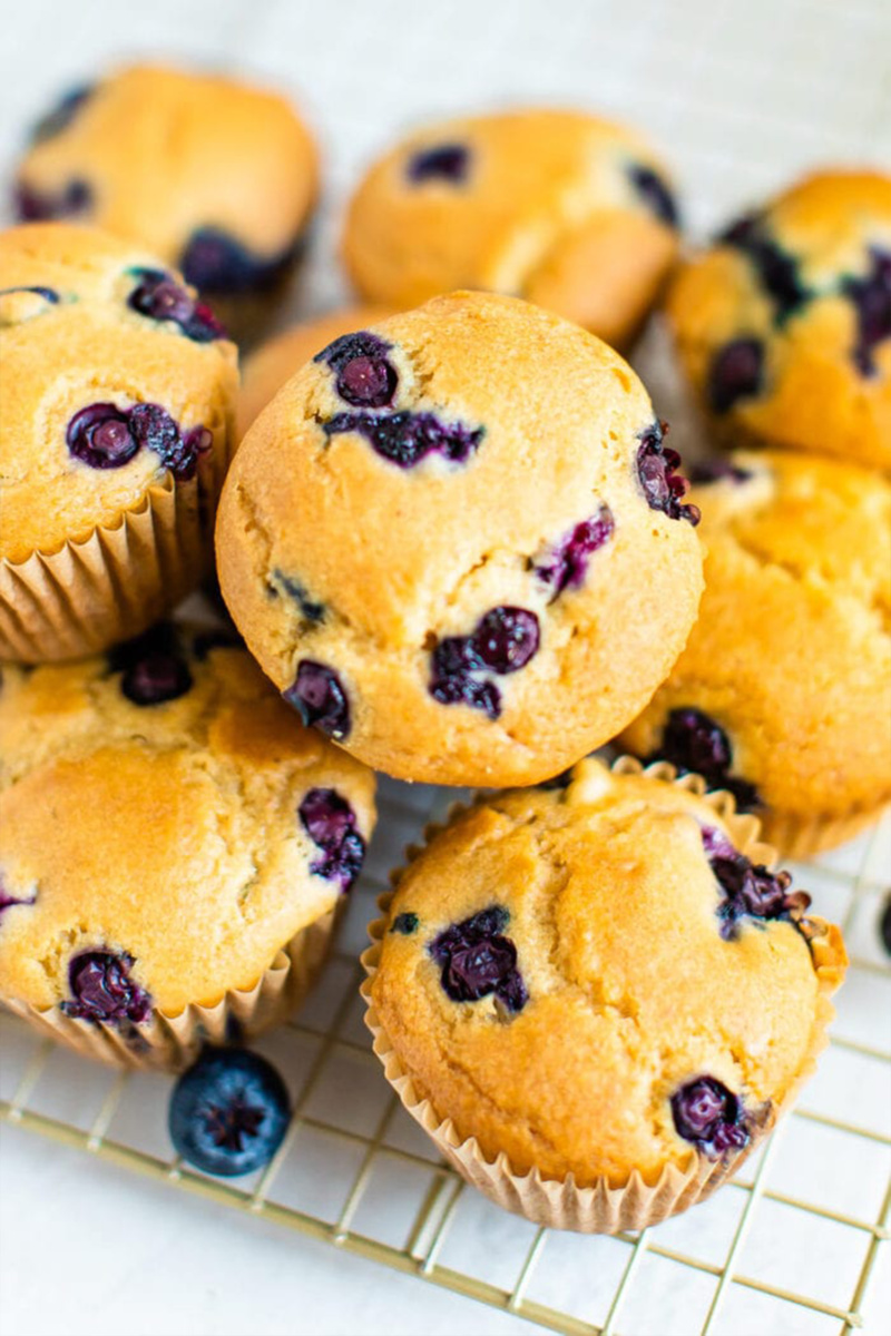 A stack of vegan blueberry muffins resting on a cooling rack