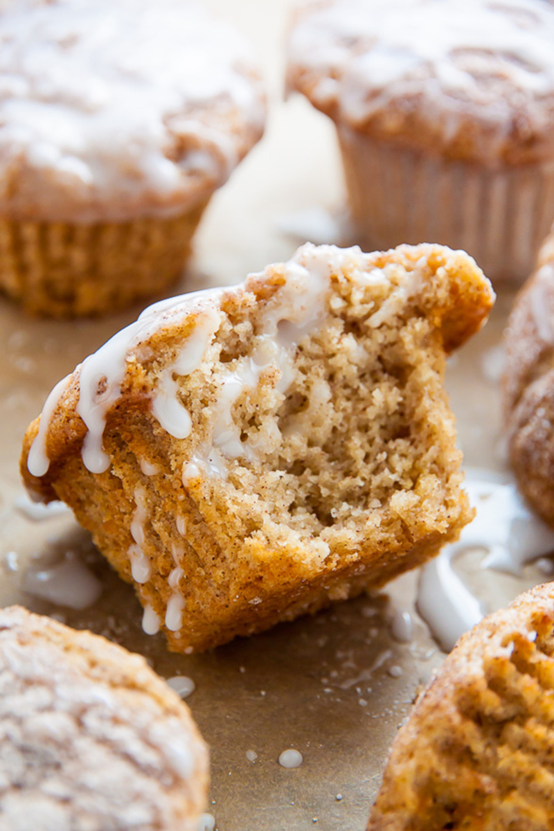 A cinnamon sugar muffin with a bite taken out of it is covered with vanilla glaze