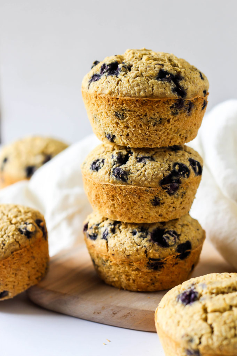 vegan blueberry cornbread muffins are stacked one on top of another