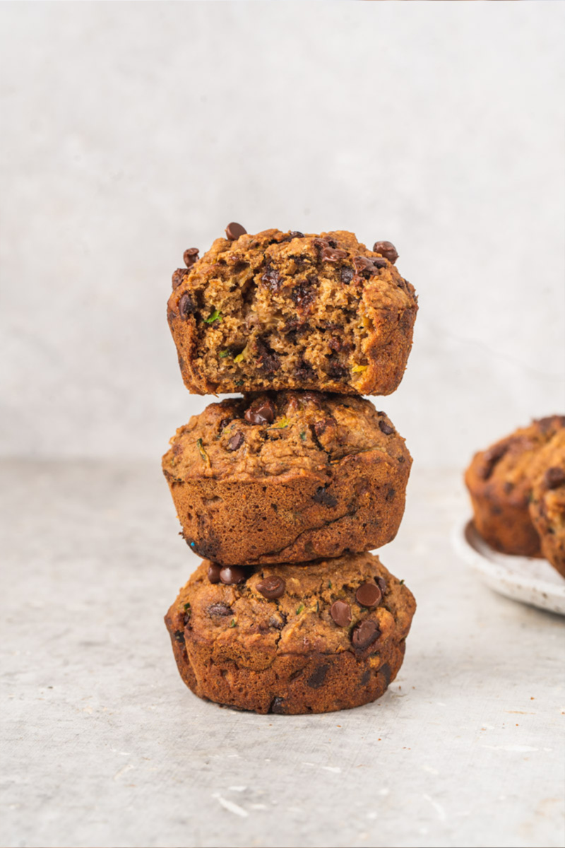 Three zucchini chocolate chip muffins stacked on top of one another