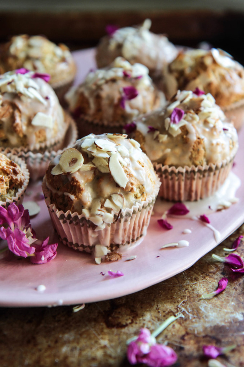 almond poppyseed muffins topped with a vanilla glaze and edible pink flowers