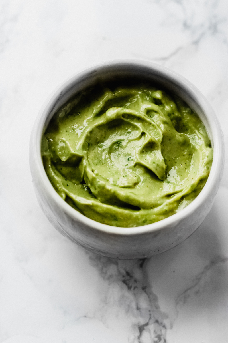 white bowl of thick green avocado sauce