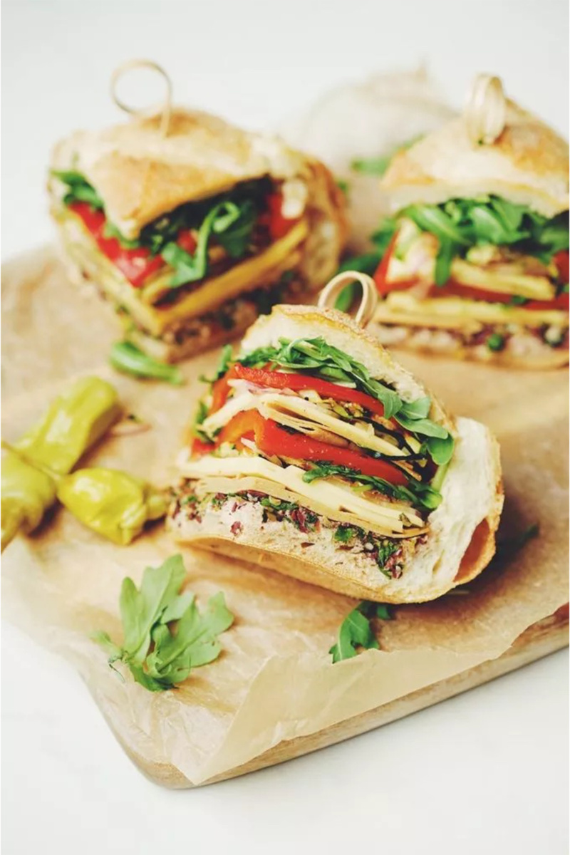 a vegan muffaletta sandwich cut into quarters and held together with toothpicks