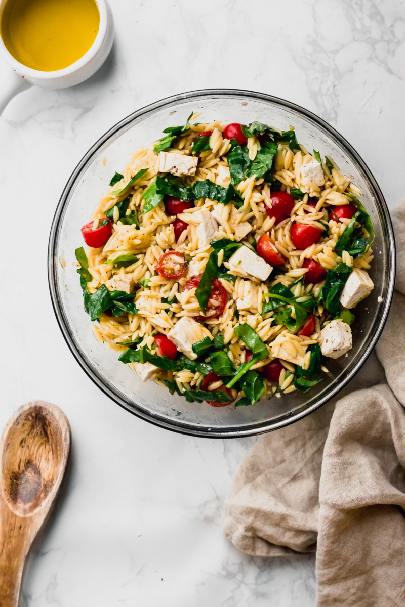 vegan caprese orzo salad with cherry tomatoes, basil and tofu feta