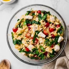 a bowl of vegan caprese pasta salad