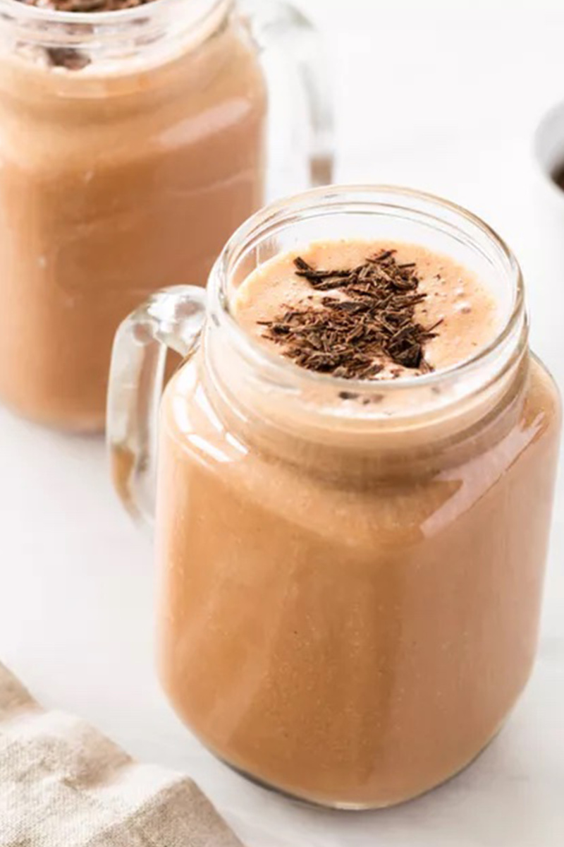 two glasses of chocolate smoothie topped with cocoa powder