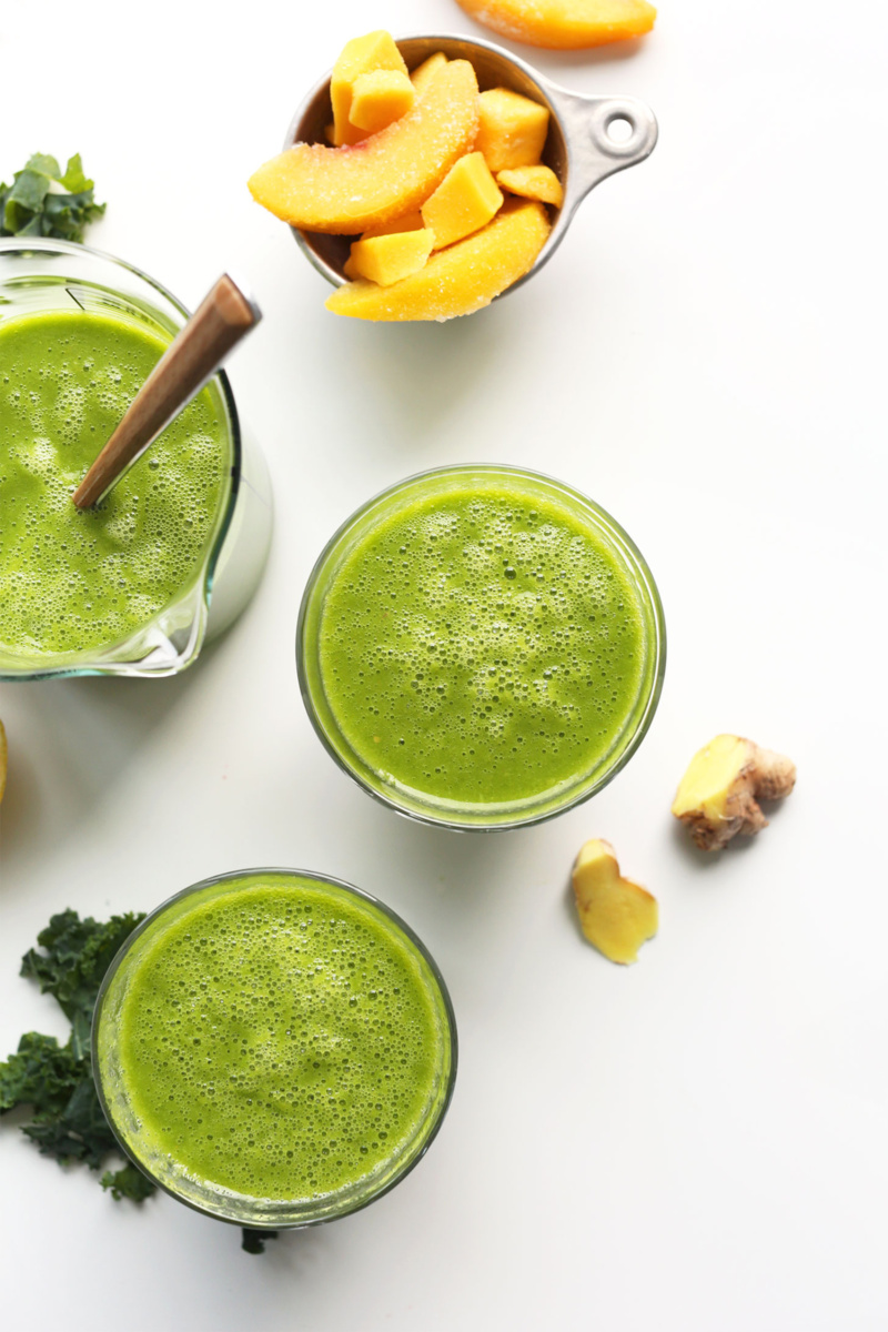 three cups of a green smoothie with a knob of ginger