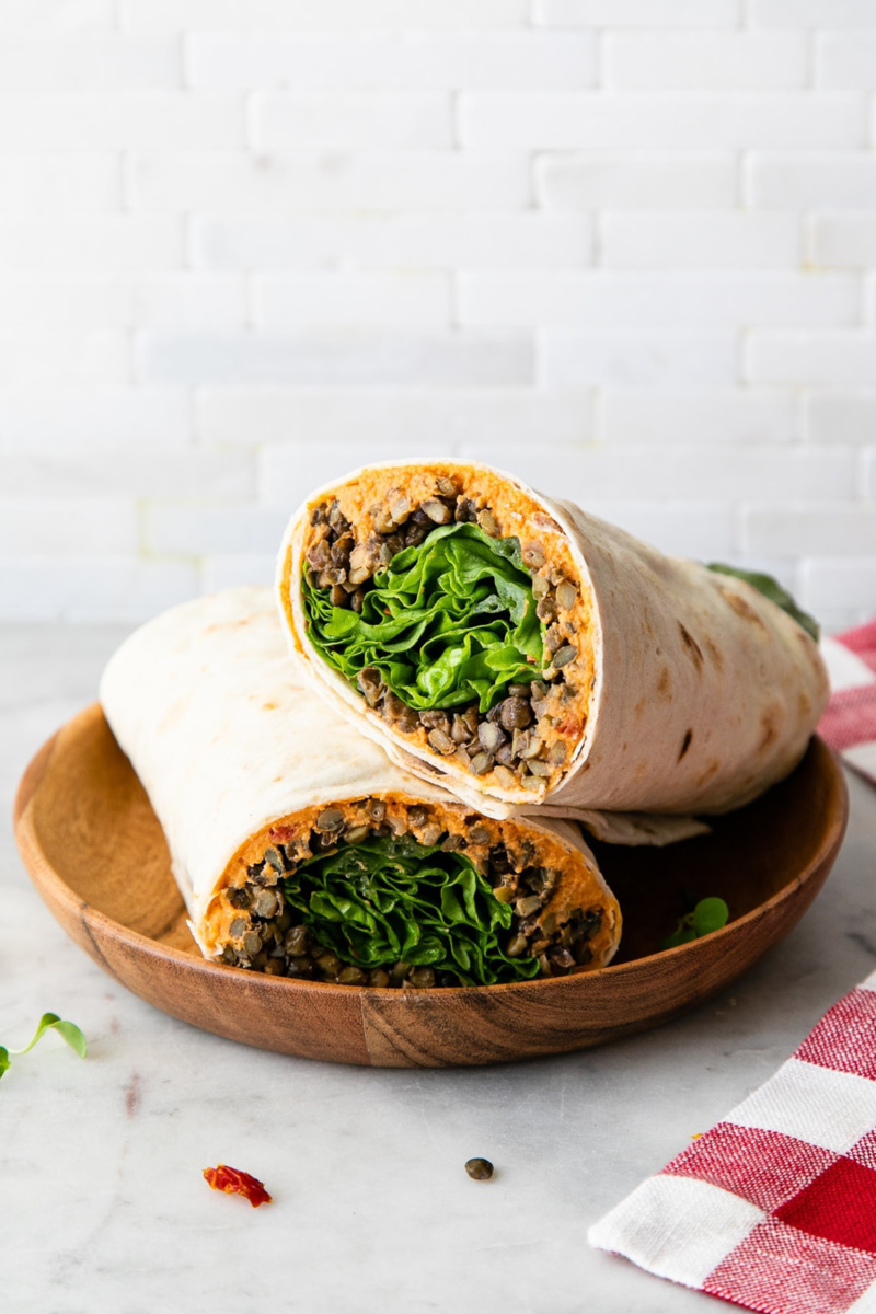 two halves of a wrap filled with lentils, greens and mashed sweet potato