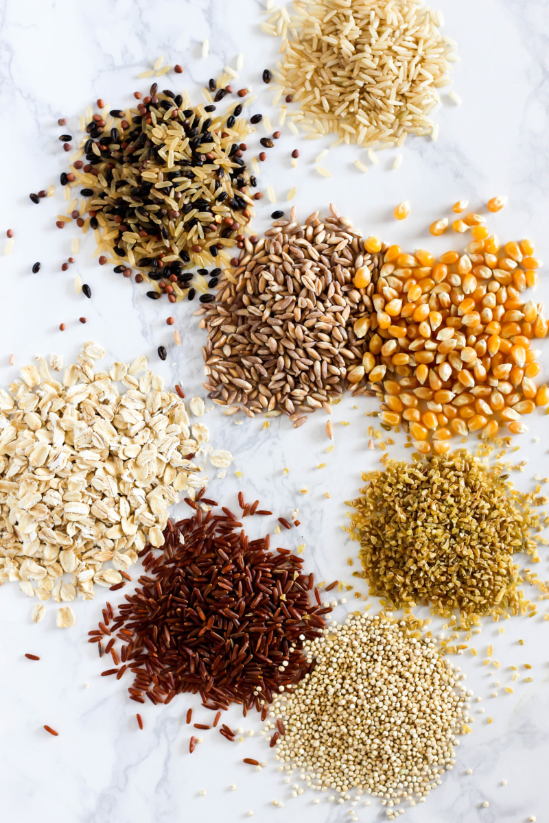 small piles of various grains such as quinoa, brown rice and oats