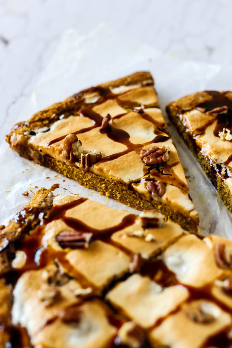 a pumpkin dessert pizza topped with chocolate sauce and pecans