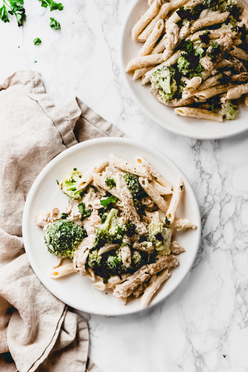 two plates of vegan chicken broccoli alfredo