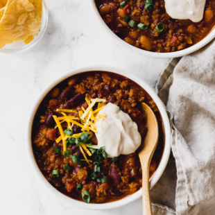 a spoon digging into a bowl of vegan chili