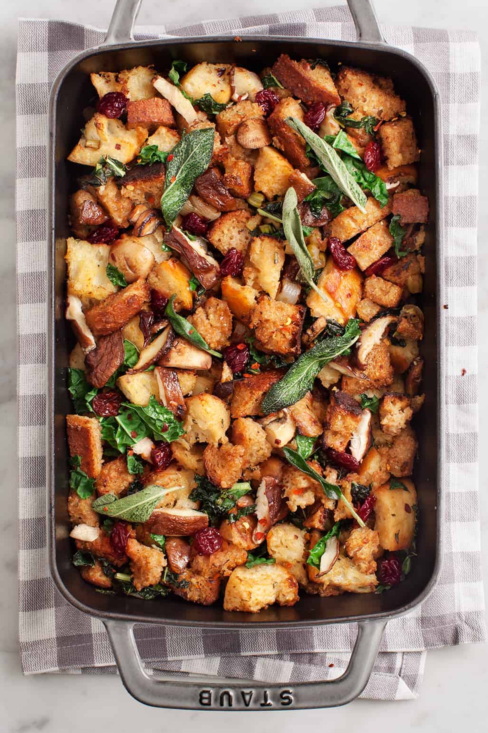 a sheet tray of vegan stuffing topped with sage leaves