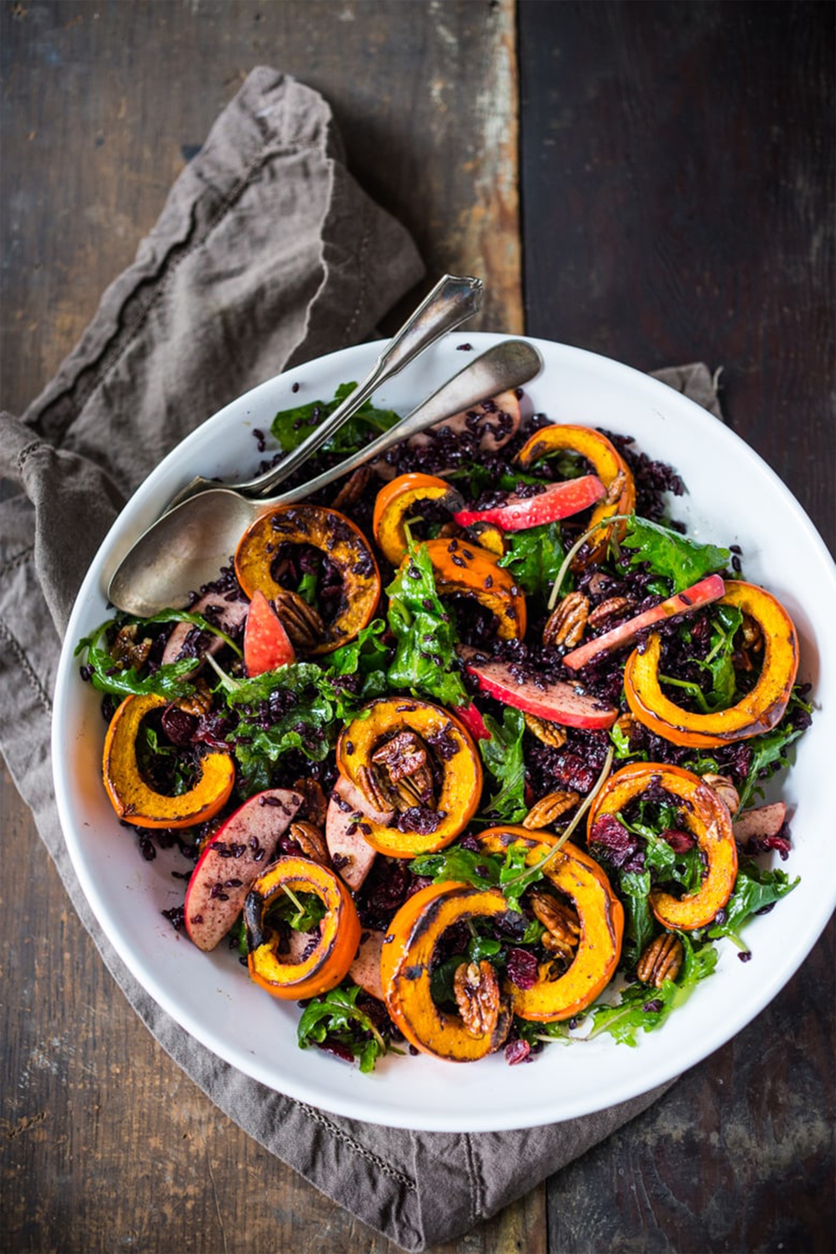 a salad topped with apples and delicata squash