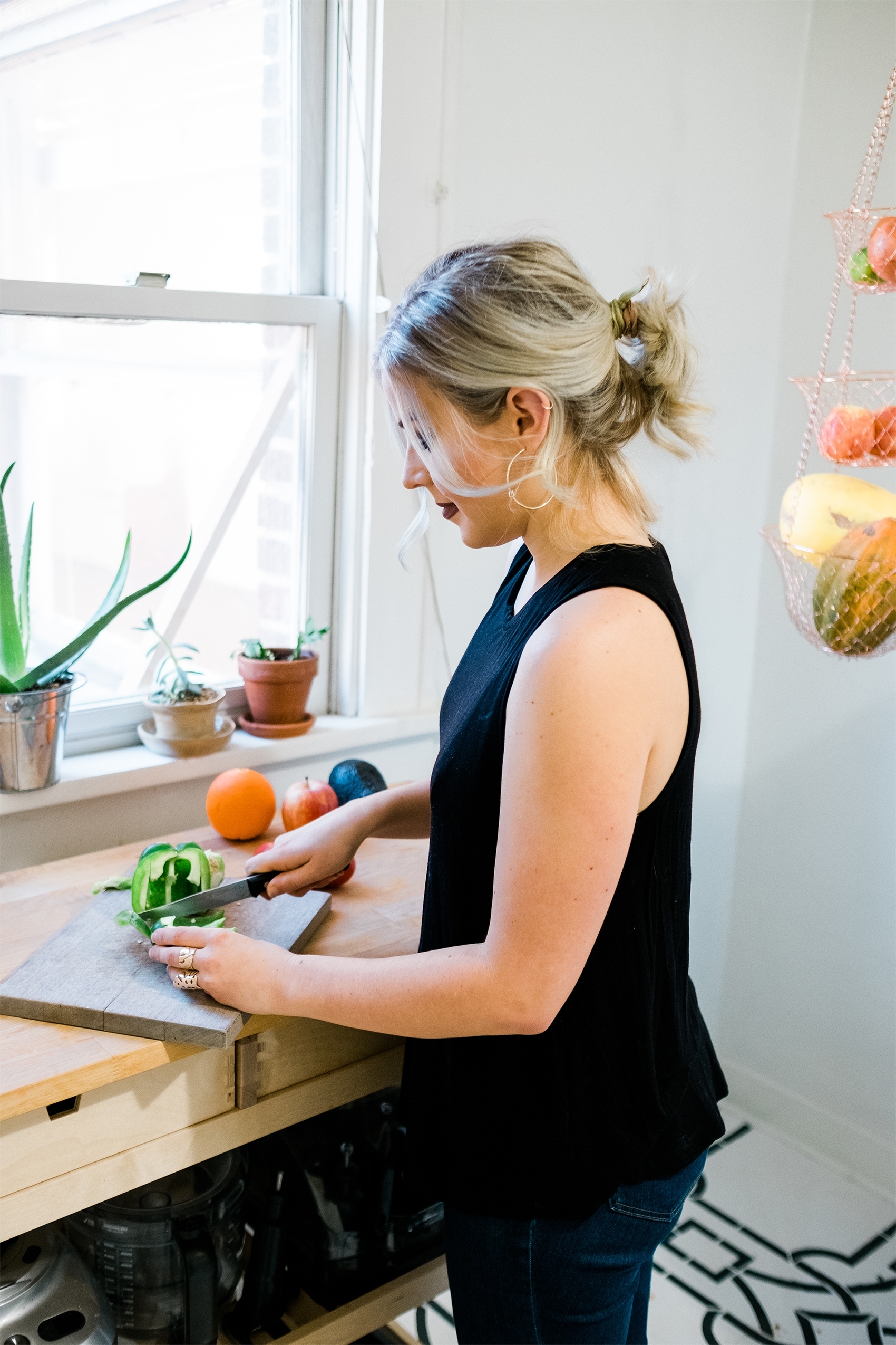 a woman chopping a green pepper