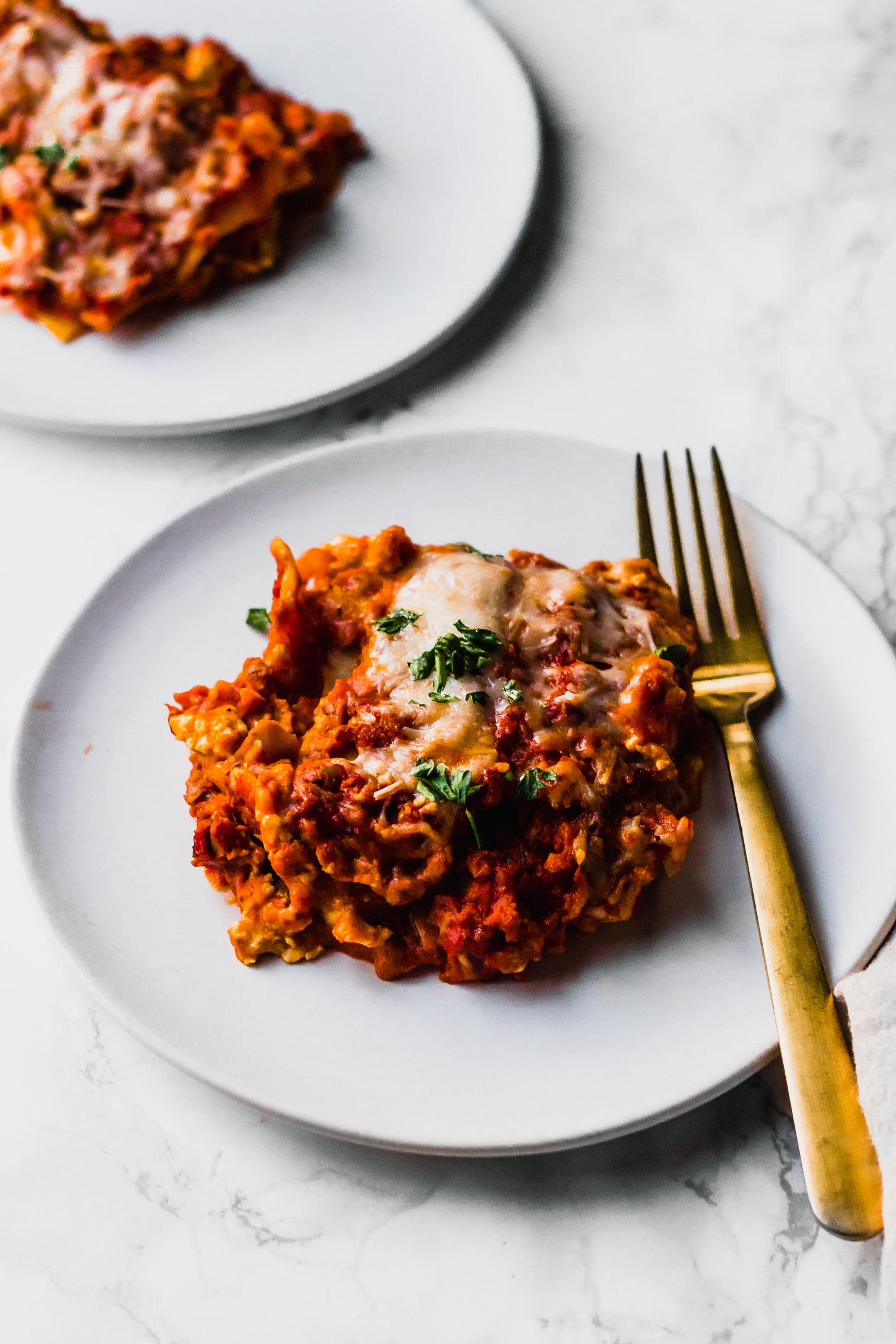 two slices of vegan lasagna topped with fresh parsley