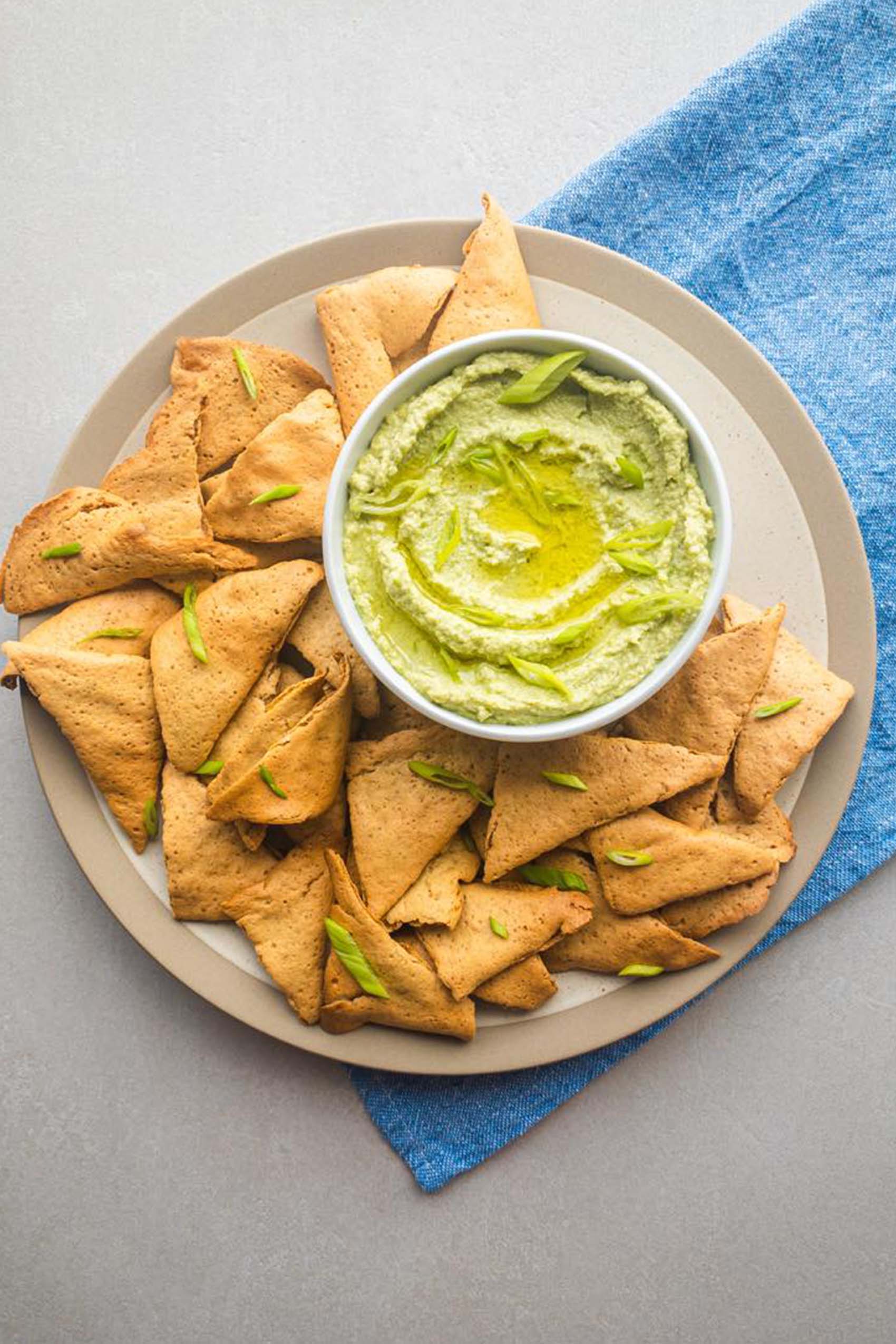 a tray of lentil chips served with a bean di[