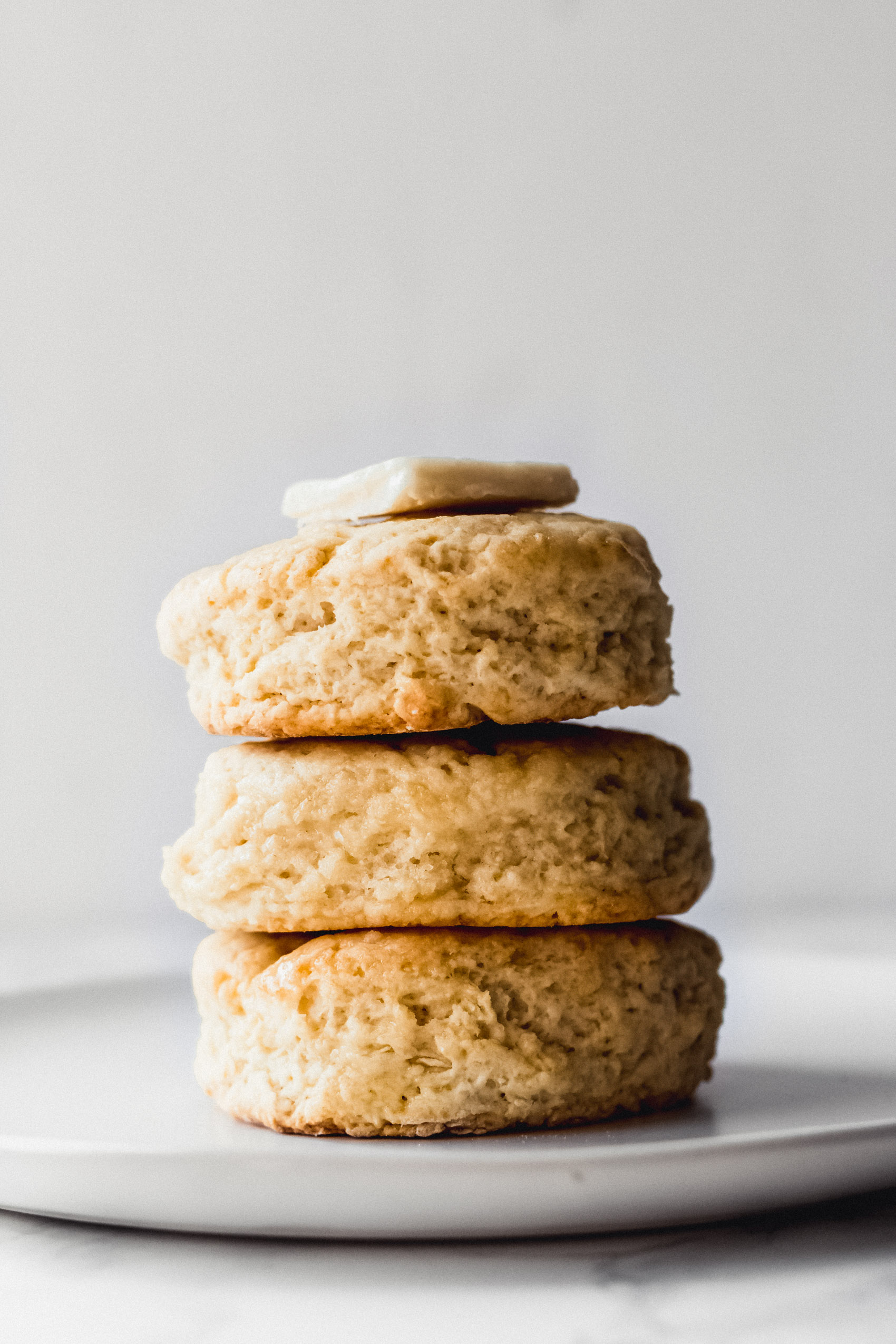 a stack of vegan biscuits topped with a pat of butter